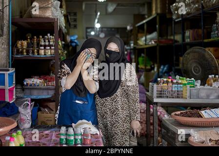 Muslimische Frau Ladenbesitzer tragen traditionelle Hijab Kopfschmuck und Coronavirus Gesichtsmaske Thailand Südostasien Stockfoto