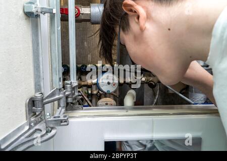 Sanitär-Schrank. Schalten Sie warmes oder kaltes Wasser. Reparatur des Wasserdrucksensors ausbauen Stockfoto