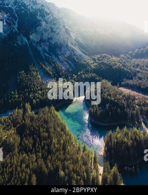 Eine Drohnenaufnahme eines Alpentales in Österreich. Das Tal hat einen Grünen See in der Mitte. Eine Landzunge mitten im See. Stockfoto