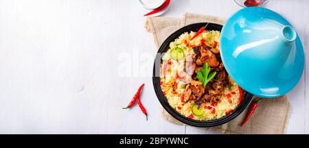 Tajin mit Couscous, Gemüse und Fleisch auf weißem Hintergrund Stockfoto