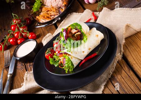 Leckere Wraps mit zog Schweinefleisch und Salat gefüllt Stockfoto