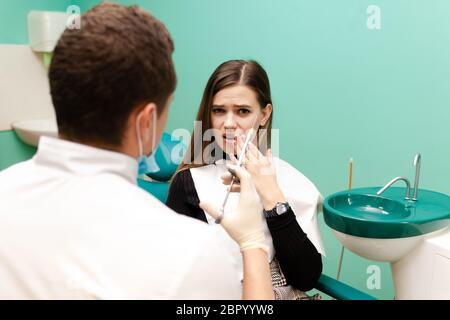 Zahnarzt Arzt hält eine Injektionsspritze. Mädchen muss eine schmerzlindernde Injektion machen. Frau hat Angst vor Injektionen Konzept. Nahaufnahme des Injektionsstifts Stockfoto