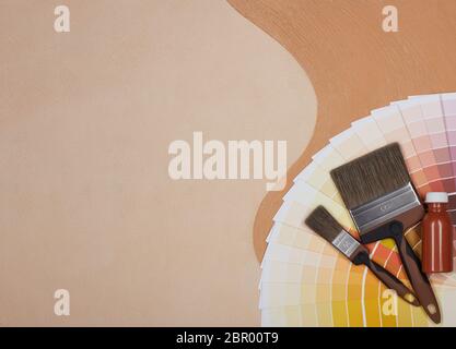 Farbpalette Führer, Pinsel und Flasche Farbe liegen auf textural doppelten Hintergrund, bestehend aus zwei beigen Farbtönen. Draufsicht mit Kopierbereich, C Stockfoto