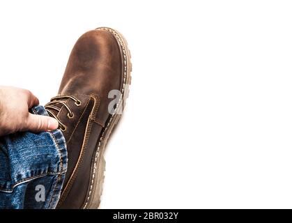 Braune Herrenstiefel und blaue Jeans. Isoliert auf weißem Grund Stockfoto