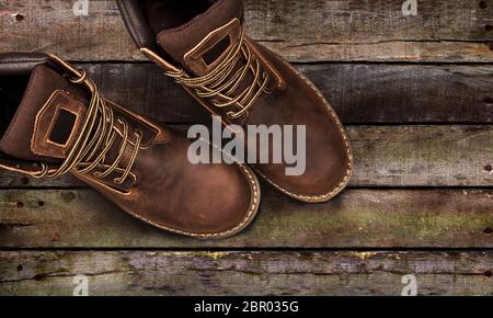 Braun Herren stiefel, auf einer hölzernen Hintergrund. Closeup isoliert Stockfoto