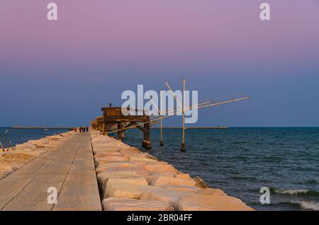 Traditionelle Fischerstationen Häuser mit Netz im Wasser der Adria am Pier Diga Sottomarina, Skyline mit Horizont und erstaunlichen Sonnenuntergang an zwei Stockfoto