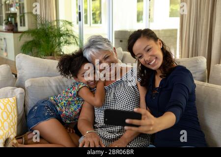 Gemischte Rassenfrau mit ihrer älteren Mutter und ihrer jungen Tochter, die ein Selfie machen Stockfoto