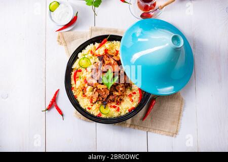 Tajin mit Couscous, Gemüse und Fleisch auf weißem Hintergrund Stockfoto