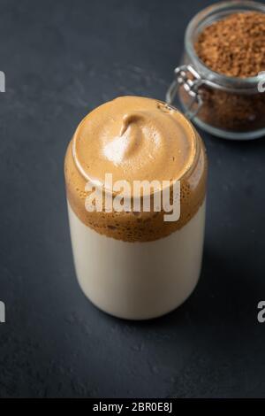 Dalgona Kaffee auf schwarz. Trendiges koreanisches Getränk mit Schaum von Instantkaffee. Vertikale Aufnahme. Nahaufnahme. Stockfoto
