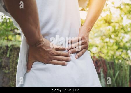 Ein Mann leiden unter Rückenschmerzen, Querschnittslähmung und Muskel Problem Problem bei Outdoor. Stockfoto