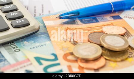 Ein Rechner mit Euro- Banknoten und Euro-Münzen Stockfoto