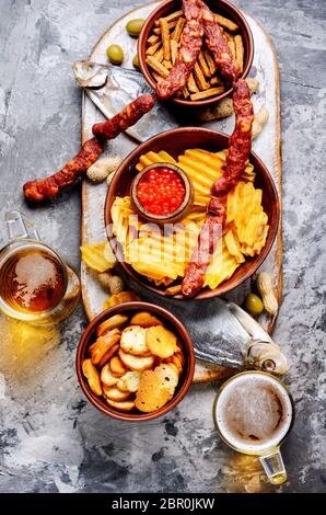 Bier und Snacks. Pommes, Fisch, Bier, Würstchen auf den Tisch Stockfoto