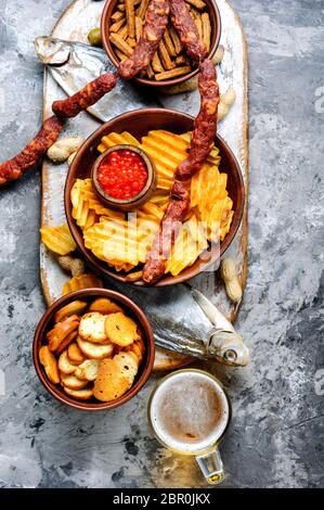 Auswahl an Bier und Snacks. Pommes, Fisch, Bier, Würstchen auf den Tisch Stockfoto