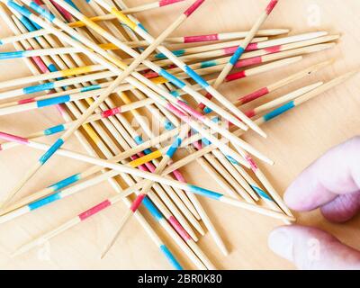 Spieler nimmt einen Stick von Stapel in Mikado Spiel schließen bis auf Holz board Stockfoto