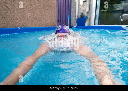 Rosyth, Schottland, Großbritannien. 20 Mai 2020. Jenny Waring (41) aus Rosyth, Fife, eine wilde Freiwasser-Schwimmerin mit der Gruppe der Fufe Wild Schwimmer, während eines täglichen Tauchens in ihrem Gartenbecken. Vielen Wildschwimpern wurde die Möglichkeit verwehrt, während der Sperrung von Covid-19 ihren Sport zu treiben, und sie haben Pools für ihre Gärten gekauft, um ihr Wohlbefinden zu erhalten. Iain Masterton/Alamy Live News Stockfoto