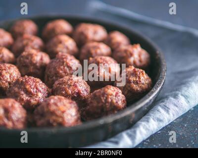 Hausgemachte gebratenem Rindfleisch Fleischbällchen in Gusseisen Skillet auf dunkelblauem Hintergrund. Kopieren Sie Platz für Text. Flache DOF Stockfoto