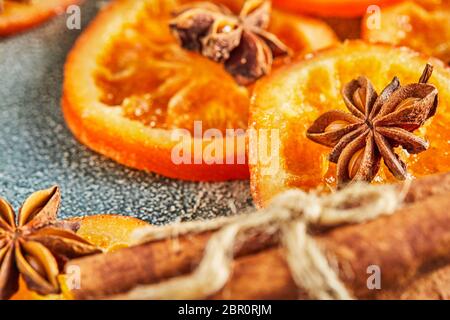 Scheiben getrockneter Orangen oder Mandarinen mit Anis und Zimt, auf blauem Hintergrund. Vegetarismus und gesunde Ernährung. Stockfoto