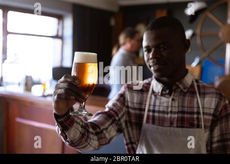 Afroamerikanischer Mann, der in einer Mikrobrauerei arbeitet Stockfoto