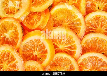 Scheiben getrockneter Orangen oder Mandarinen auf blauem Hintergrund. Vegetarismus und gesunde Ernährung. Nahaufnahme Stockfoto