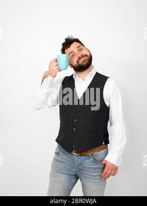 Gut aussehender, junger Mann mit schwarzen Bart mit Türkis Tasse Kaffee oder Tee Tasse vor weißem Hintergrund posiert und die verschiedenen Gesichtsausdrücke Stockfoto