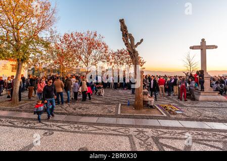 30. November 2019 - Granada, Spanien. Touristen und Einheimische treffen sich, um den wunderschönen Sonnenuntergang über dem Alhambra Palast aus dem Blickwinkel von Mirado zu genießen Stockfoto