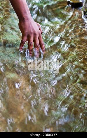 Wasser, Quelle des Lebens, und die Hand eines Jungen Stockfoto