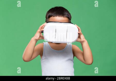 Kleiner Junge, der sich durch Virtual Reality Gerät Stockfoto