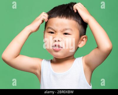 Kleiner Junge kratzte sich am Kopf Stockfoto