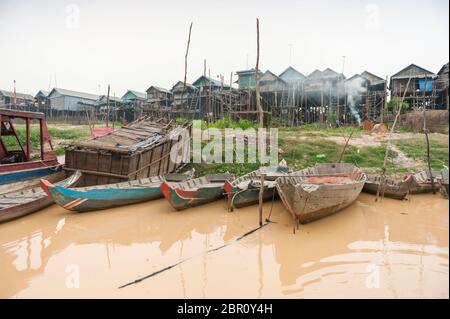 Boote auf dem Fluss mit Häusern auf Stelzen im Hintergrund bei Kampong Phluk, Provinz Siem Reap, Nord-Zentral Kambodscha, Südostasien Stockfoto