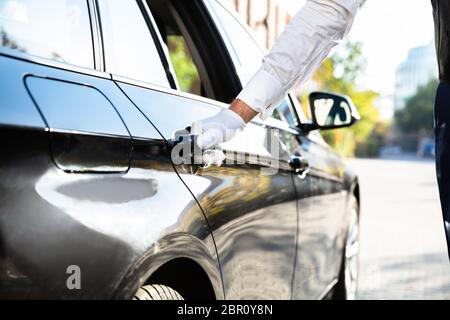 Der Parkservice Hand Öffnen schwarzes Auto Tür auf der Straße Stockfoto