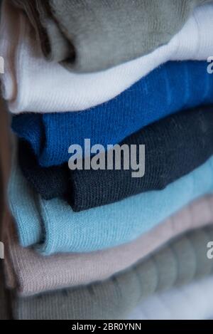 Socken aus feinem Jersey. Blick von oben. Viele Socken auf einem hölzernen Hintergrund. Socken in verschiedenen Farben. Strickmode. Stockfoto