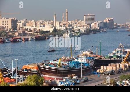 Dubai Creek in Dubai, VAE, mit Daus und Booten, die an Kais festgemacht werden, die be- und entladen werden Stockfoto