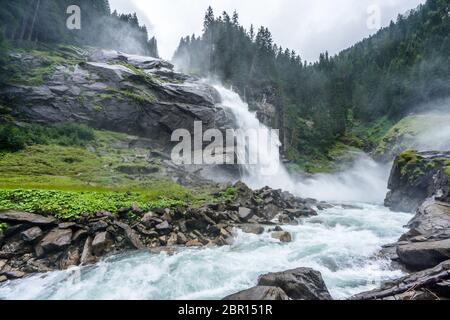 Blick auf die Krimmler Wasserfälle von unten an einem nassen und bewölkten Tag in Österreich. Majestätischer Bach, der am höchsten Wasserfall europas fließt Stockfoto