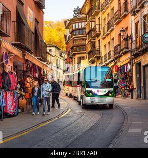 Granada, Spanien - November 30 2019. Ein Touristenzug, der Touristen von Alhambra hinunter in Richtung Plaza Nueva durch die Straße Cuesta de Gomerez bringt. Stockfoto