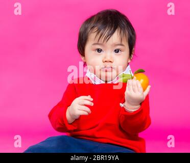 Kleiner Junge mit chinesischen Mandarinen Stockfoto