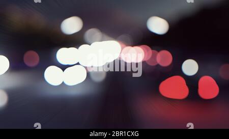 Defokussed Autos Lichter und Hintergrundbewegung. Autos mit Licht fahren nachts durch die Stadt. Stockfoto