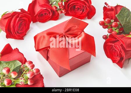 Geschenkbox und rote Rosen auf weißem Hintergrund Draufsicht Stockfoto