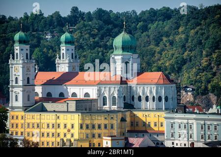 Die St. Stephens Basilika ist eine alte weiße Kirche mit grünen Metallkuppeln auf den Türmen in Passau. Stockfoto