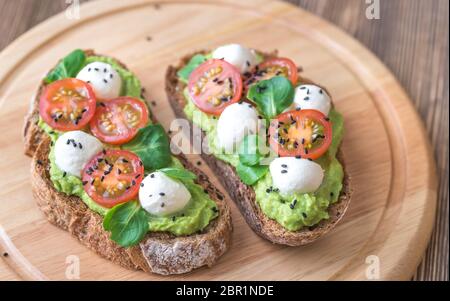 Sandwiches mit Avocado einfügen, Cherry Tomaten und Mozzarella Stockfoto