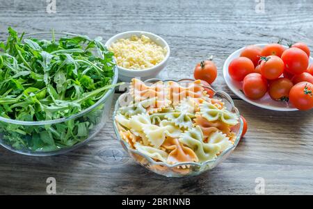 Tricolore Farfalle mit Rucola, Parmesan und Cocktailtomaten Stockfoto