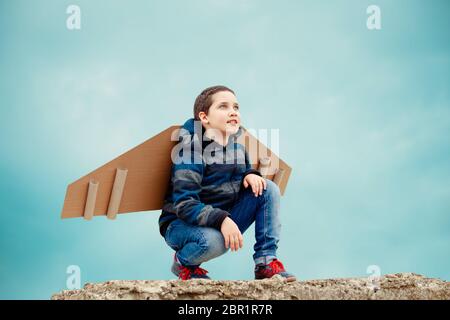 Junger Geschäftsmann mit Spielzeugpapierflügeln. Erfolg, Kreativität und Start-up Stockfoto