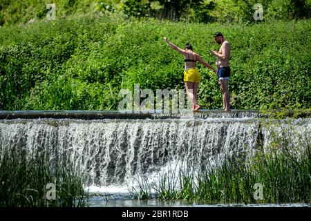 Die Menschen genießen das Wasser in Warleigh Weir am Fluss Avon in Somerset, während die Temperaturen über das Vereinigte Königreich steigen. Stockfoto