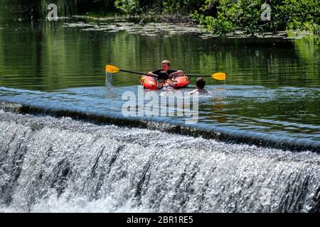 Die Menschen genießen das Wasser in Warleigh Weir am Fluss Avon in Somerset, während die Temperaturen über das Vereinigte Königreich steigen. Stockfoto