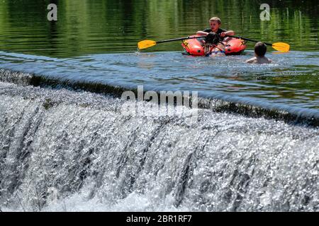 Die Menschen genießen das Wasser in Warleigh Weir am Fluss Avon in Somerset, während die Temperaturen über das Vereinigte Königreich steigen. Stockfoto
