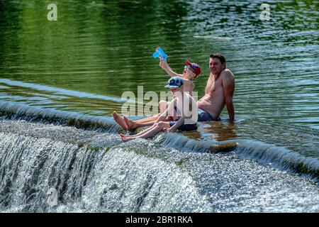 Die Menschen genießen das Wasser in Warleigh Weir am Fluss Avon in Somerset, während die Temperaturen über das Vereinigte Königreich steigen. Stockfoto