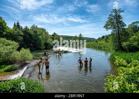 Die Menschen genießen das Wasser in Warleigh Weir am Fluss Avon in Somerset, während die Temperaturen über das Vereinigte Königreich steigen. Stockfoto