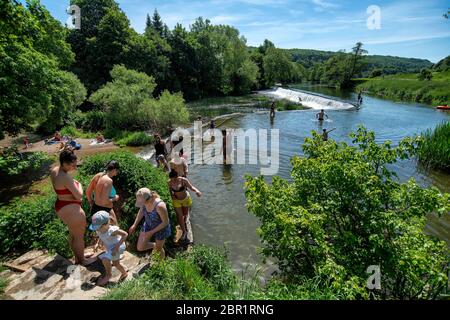 Die Menschen genießen das Wasser in Warleigh Weir am Fluss Avon in Somerset, während die Temperaturen über das Vereinigte Königreich steigen. Stockfoto