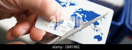 Männliche Hand schneiden Bankkarte mit Schere Stockfoto