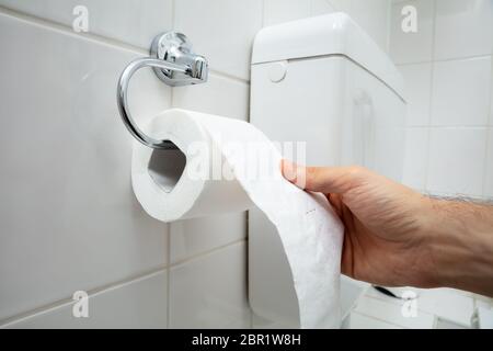 In der Nähe der menschlichen Hand mit Toilettenpapier im Bad Stockfoto