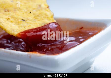 Dreieckige Maischips, mexikanische Nachos Dips mit Tomatenketchup Soßen, Nahaufnahme. Stockfoto